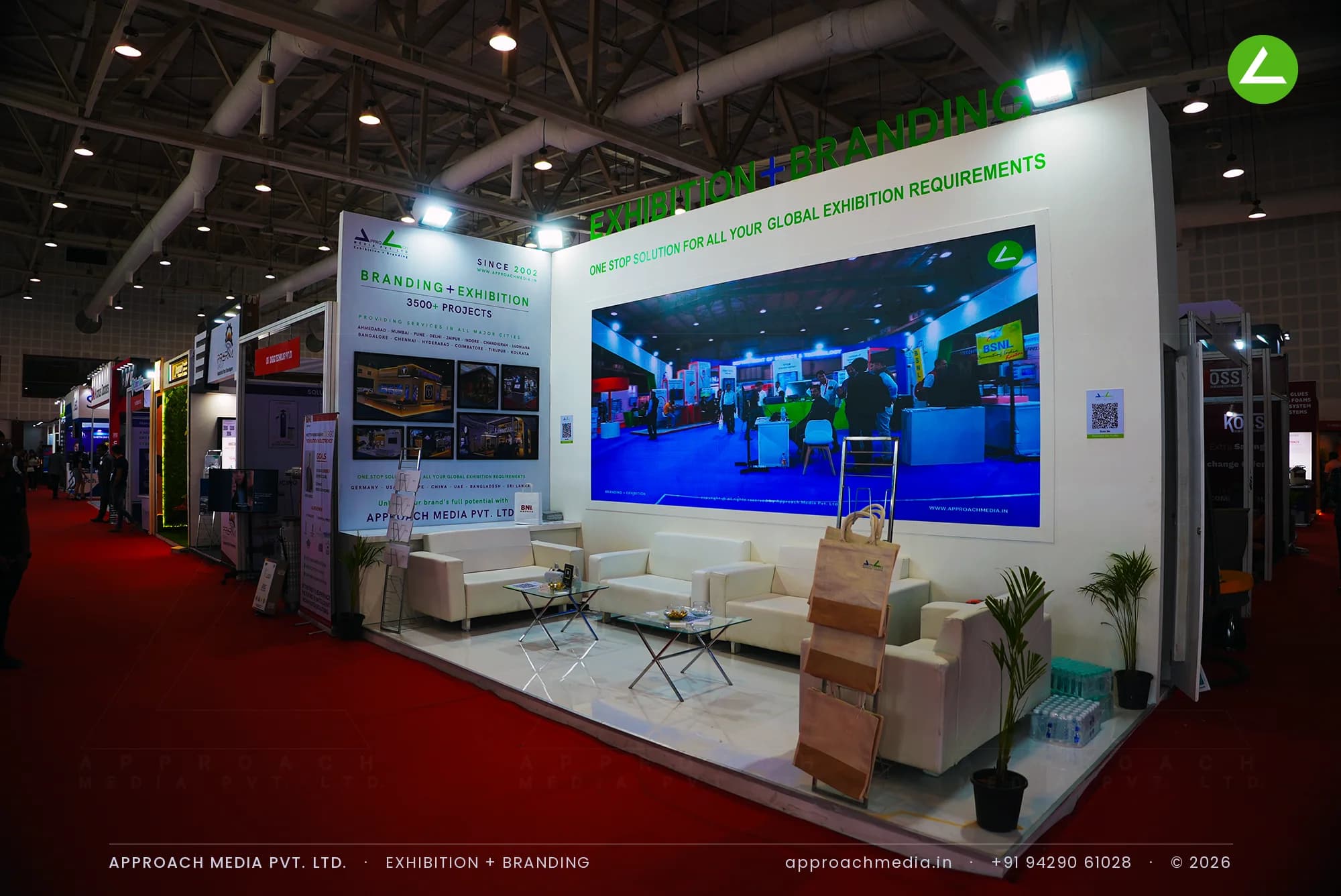 A full-width LED video wall in Approach Media's stand, with green cut-out lettering standing above the wall's top edge.