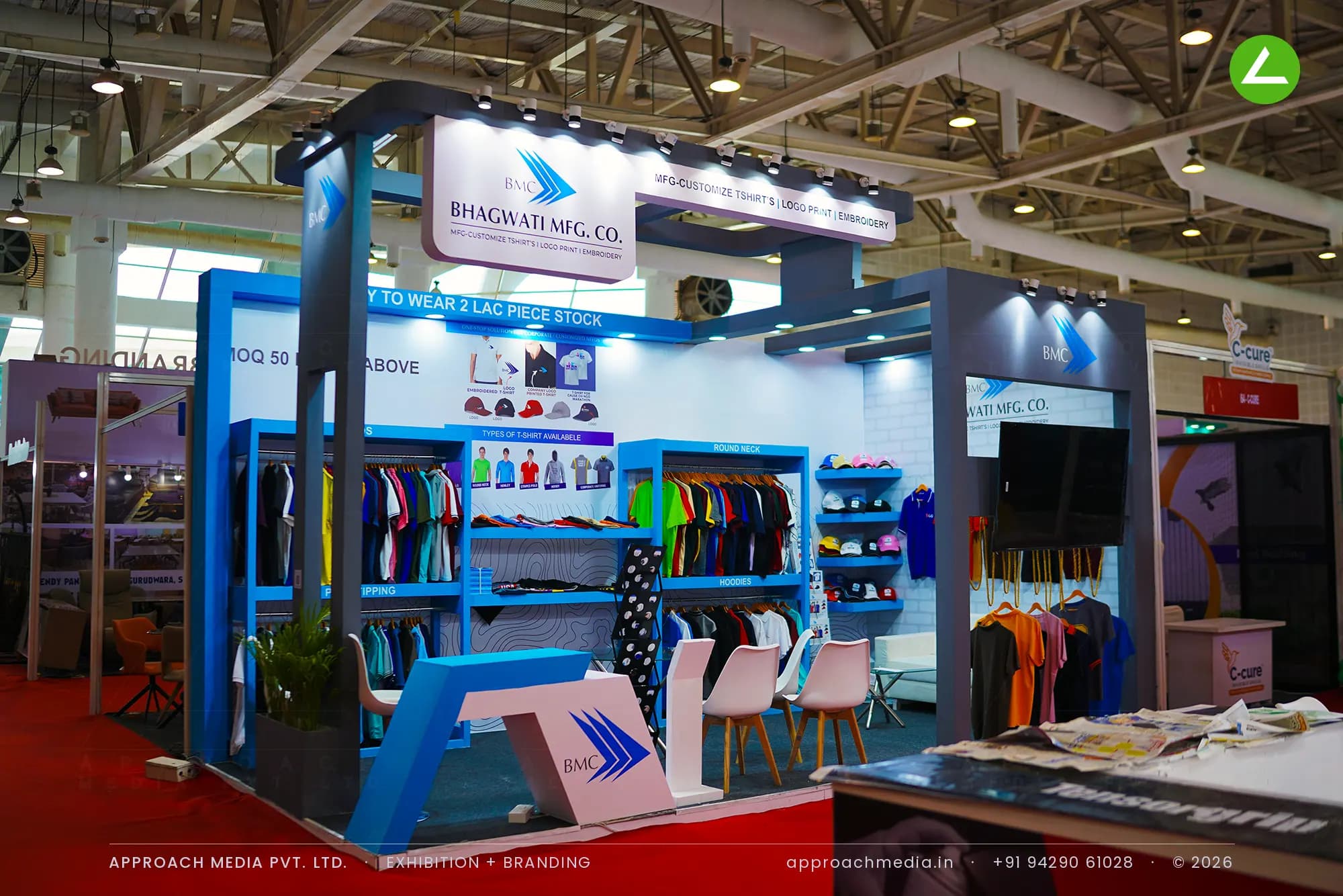 Bhagwati Mfg Co exhibition stall design at BNI Symposium Gandhinagar with blue garment racks and a suspended logo panel