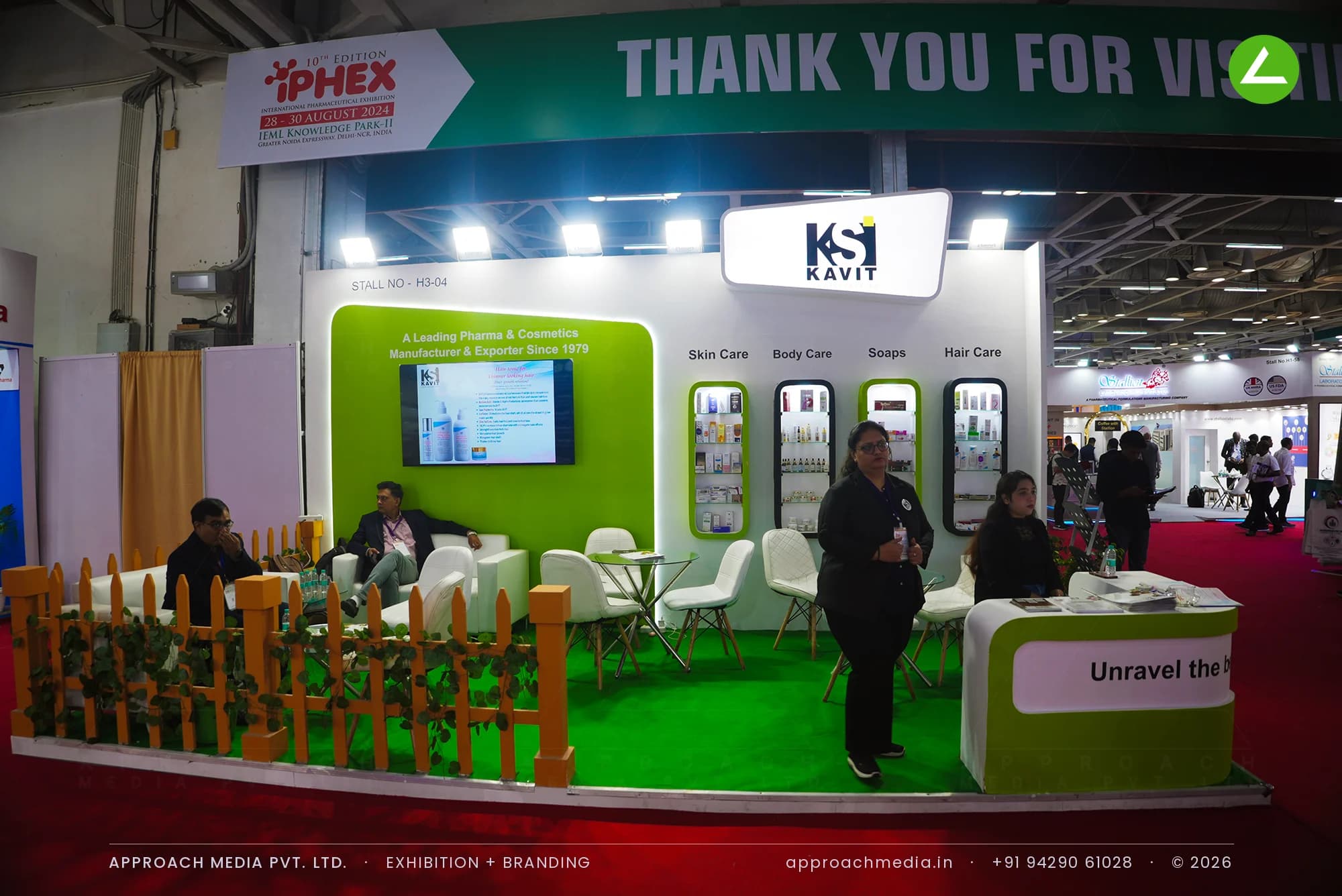 Kavit exhibition stall design at IPEX Expo Noida, green stand with four lit product niches and picket-fence edging