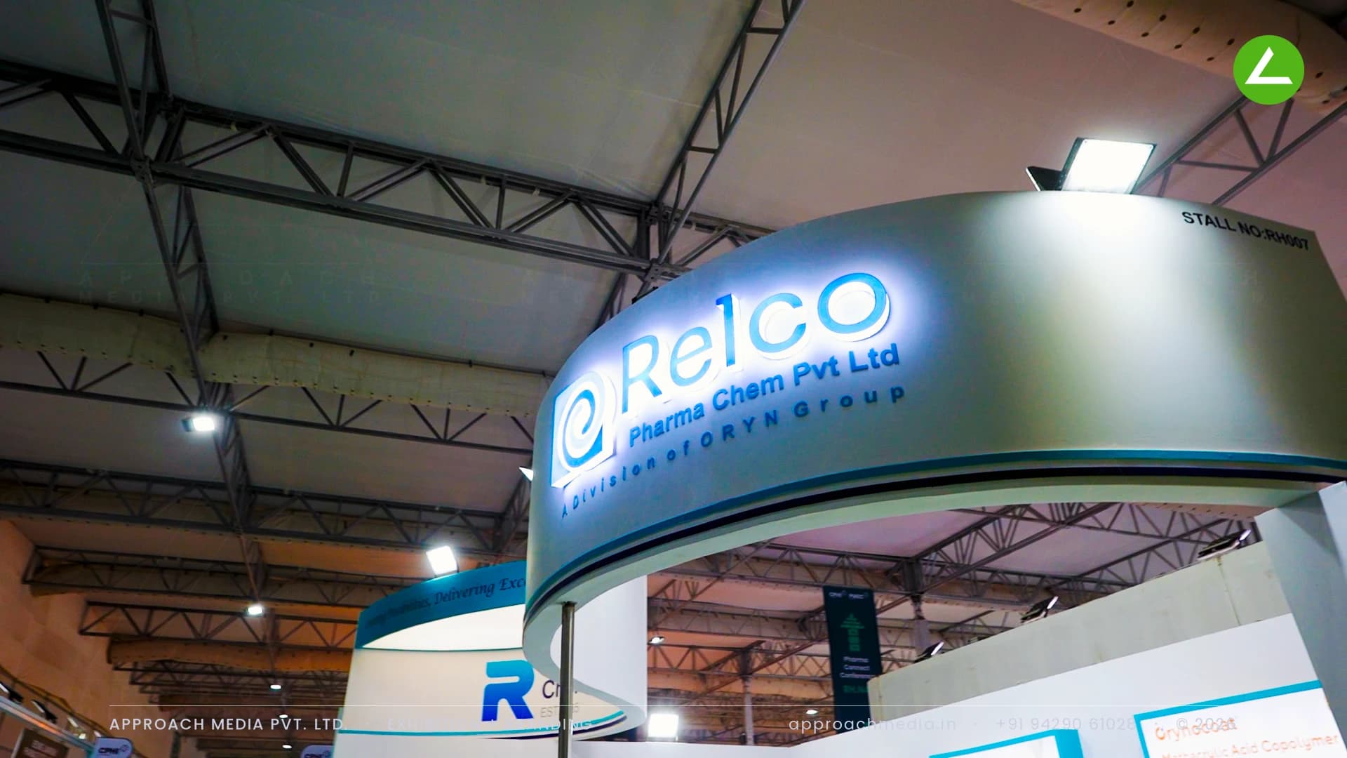 Relco Pharma Chem exhibition stall design at CPHI Greater Noida, its curved fascia carrying backlit acrylic brand lettering