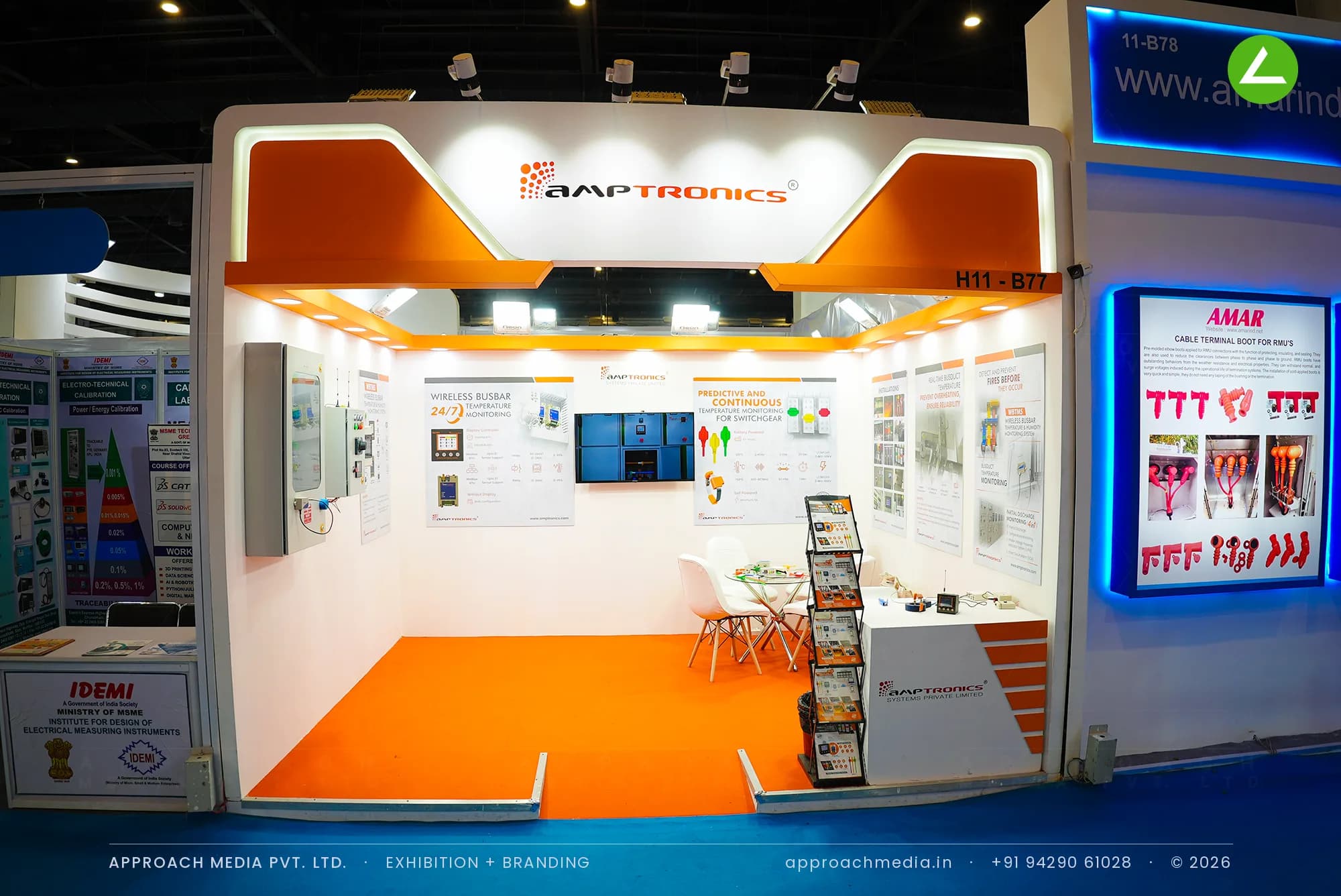 Amptronics orange and white exhibition stall design at ELECRAMA Greater Noida with lit chamfered fascia and orange floor