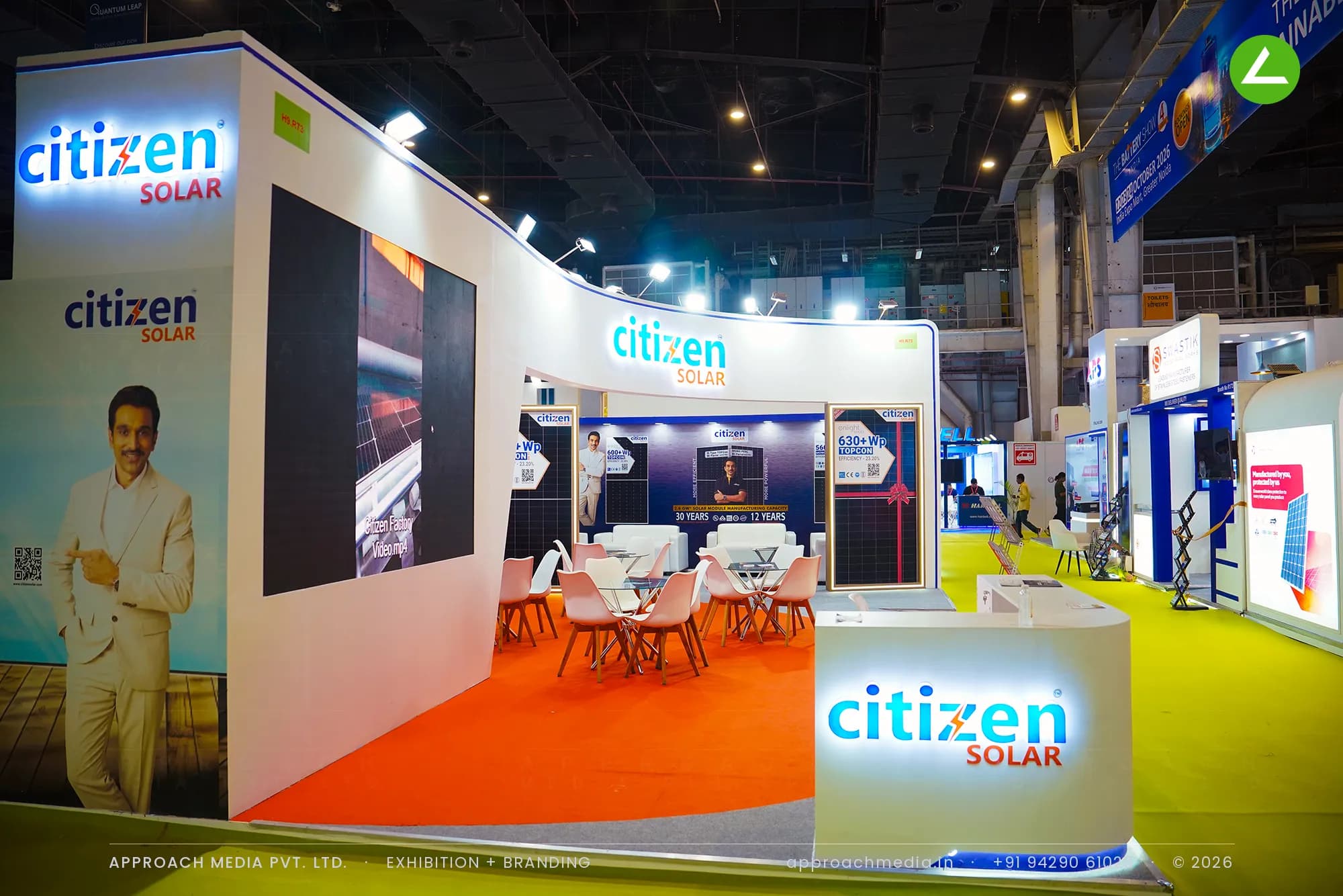 Citizen Solar exhibition stall design at REI Expo Greater Noida with a curved backlit header and orange carpet meeting zone