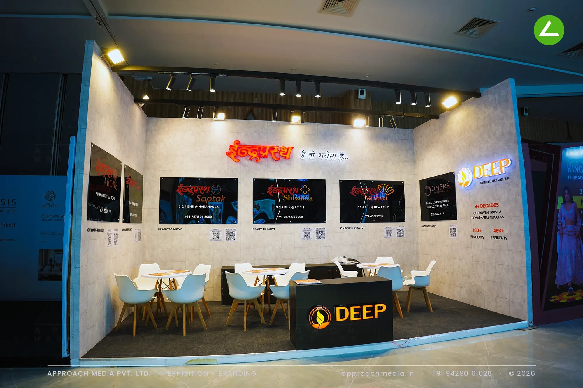 Deep Indraprasth exhibition stall design at Times Property Expo Ahmedabad with backlit red Devanagari signage