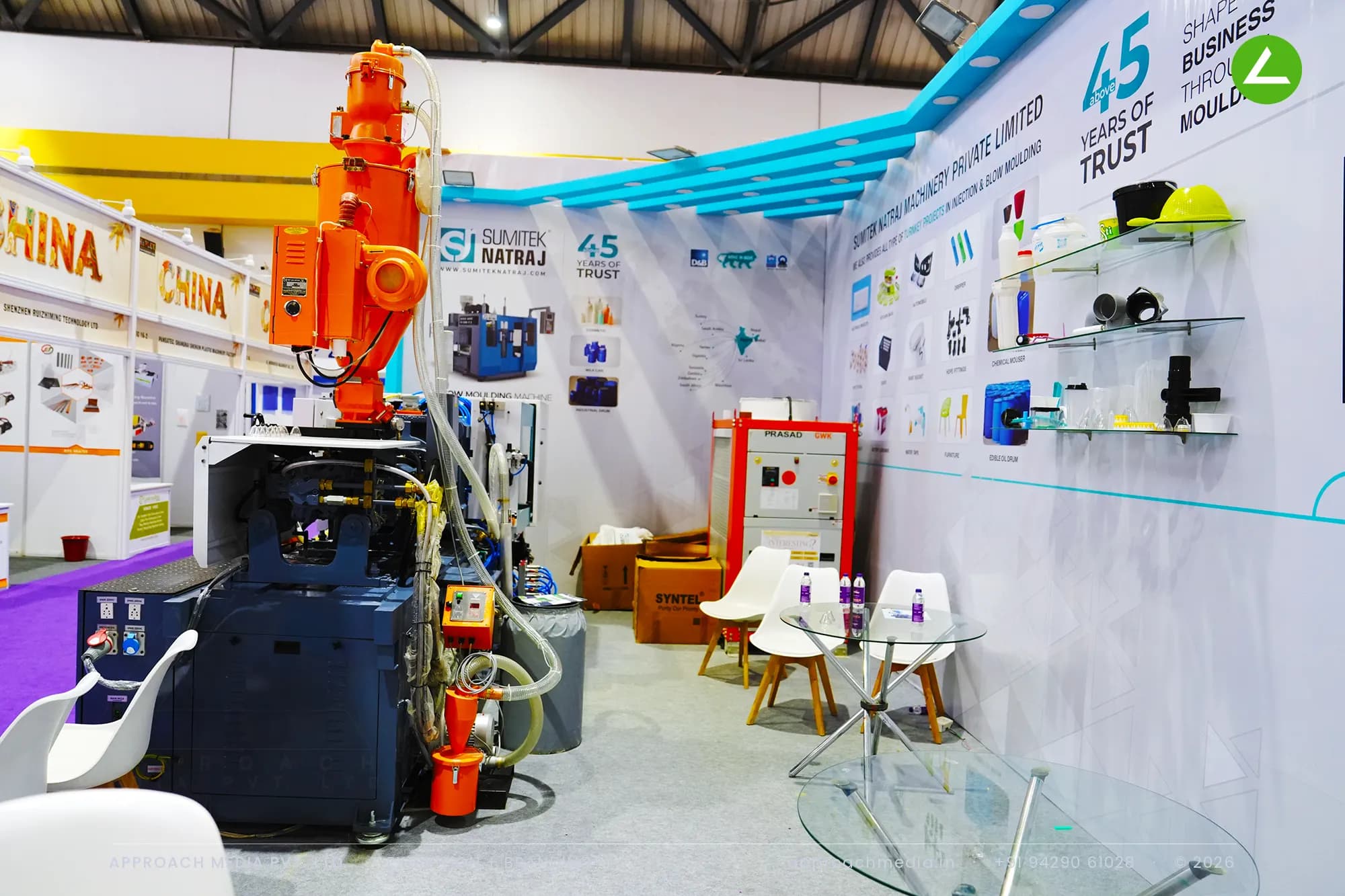 A blow moulding machine anchors the exhibition stall design at Hiplex Hyderabad for Sumitek Natraj and its sample shelves