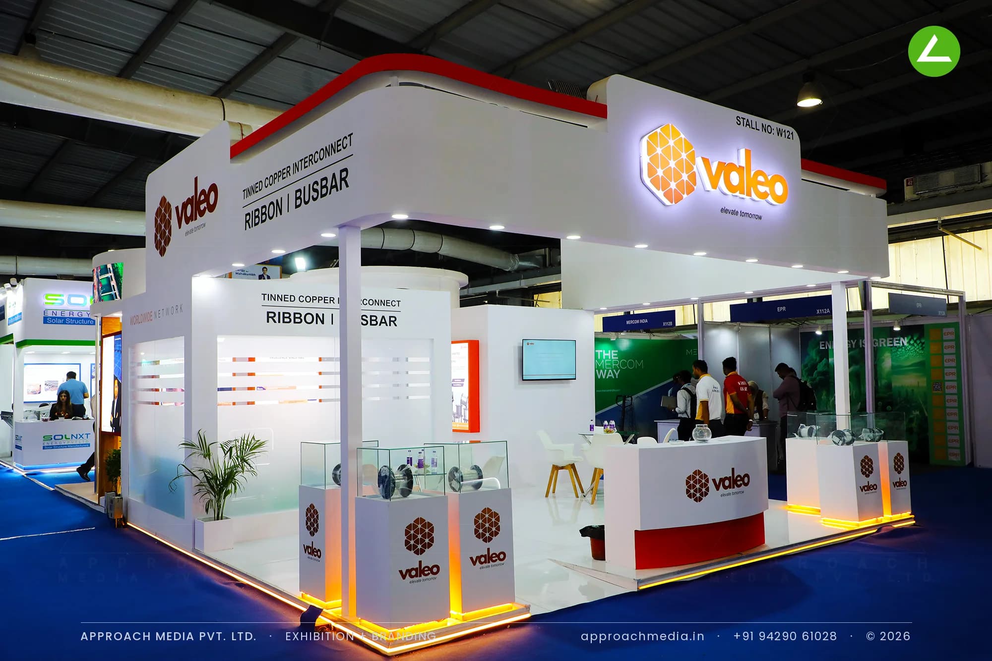 Valeo white and red exhibition stall design at Intersolar India Gandhinagar with amber-lit copper ribbon plinths