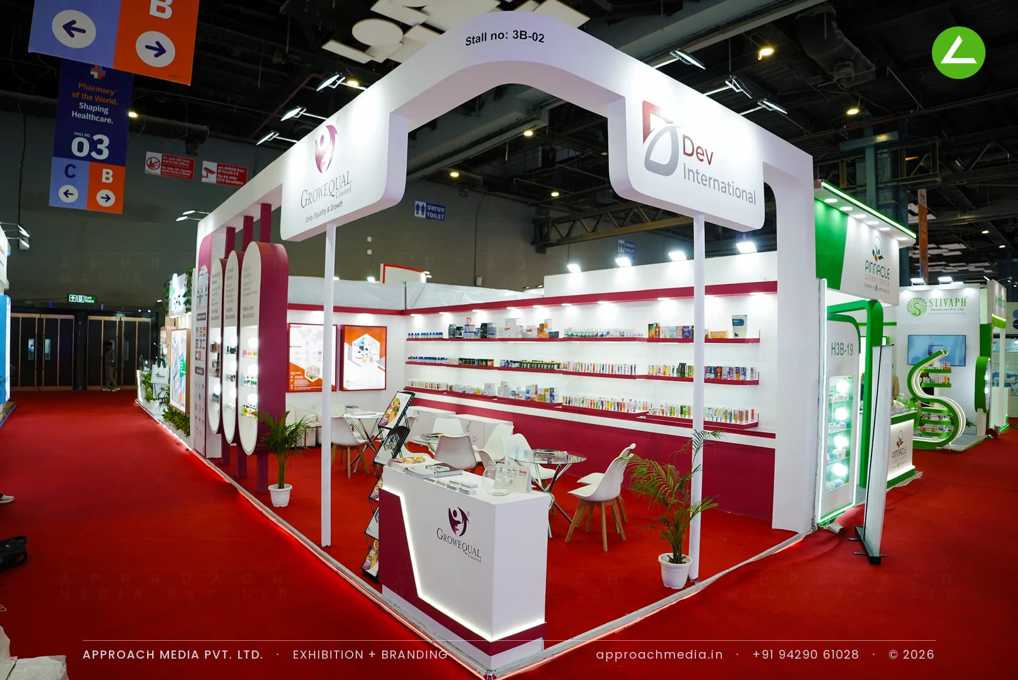White arch portal and maroon-edged shelf walls in Dev International's exhibition stall design at IPHEX New Delhi
