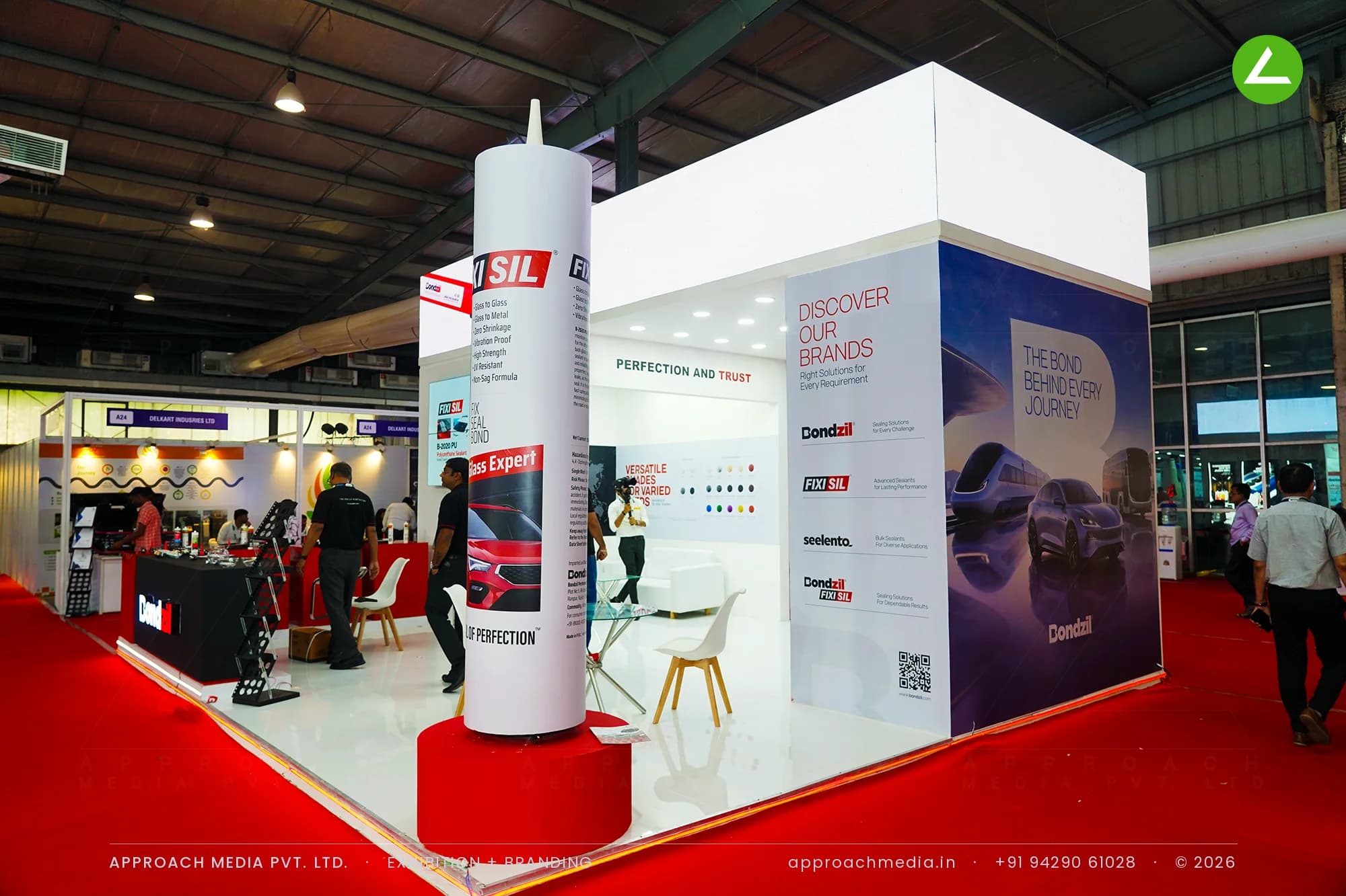 An oversized sealant cartridge column marks the exhibition stall design at Prawaas Gandhinagar, Bondzil's white island cube